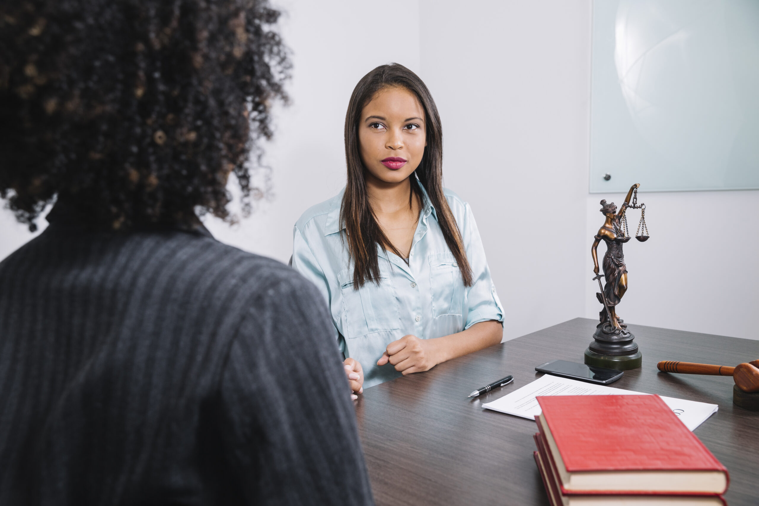 african american women sitting table near document pen figure gavel scaled